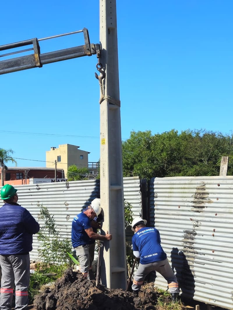 Equipe da Expresso Soluções implantando poste de concreto com guindaste