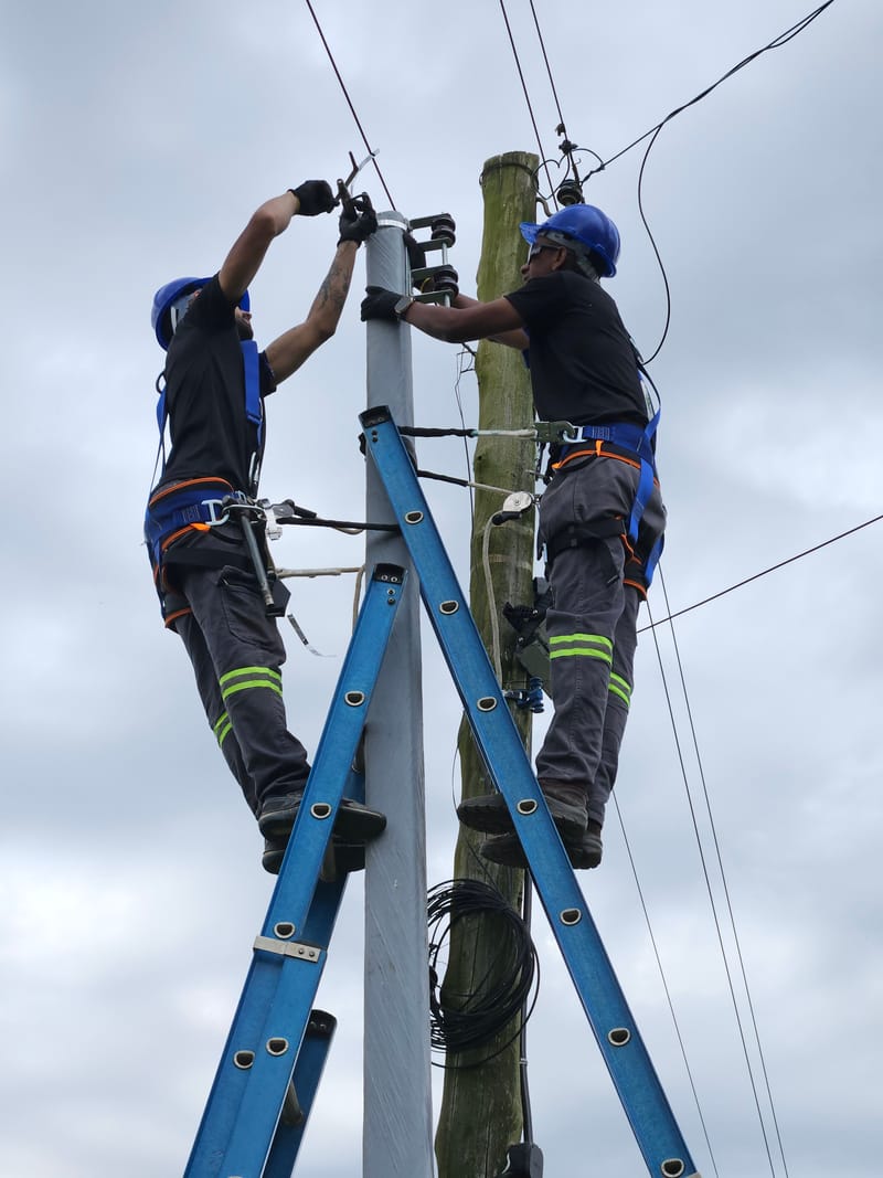 Técnicos da Expresso Soluções trabalhando em rede elétrica de distribuição em poste